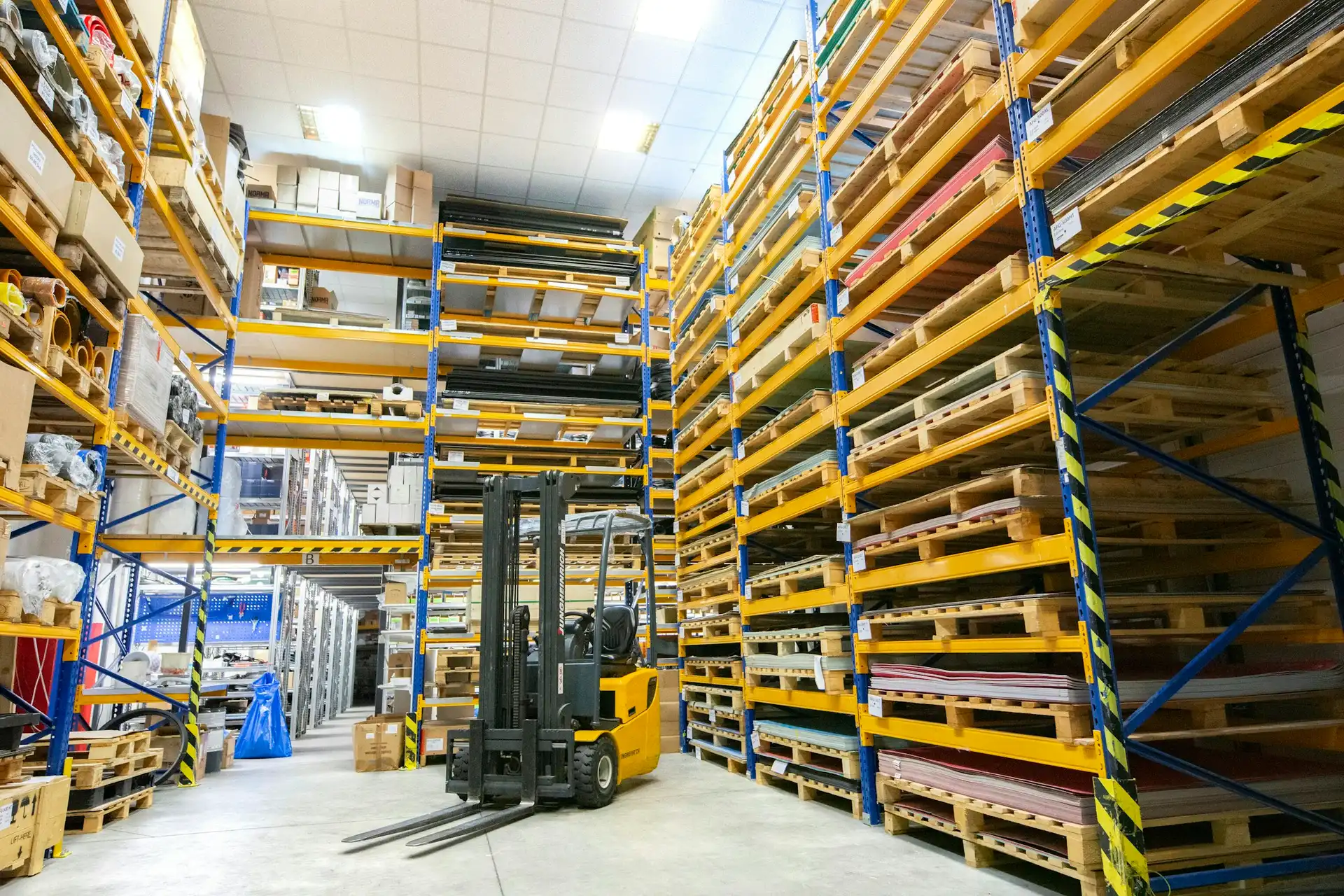 A forklift moving stock down a warehouse aisle